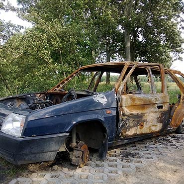 Wrak spalonego samochodu stoi przy drodze Koczewo – Sierosaw